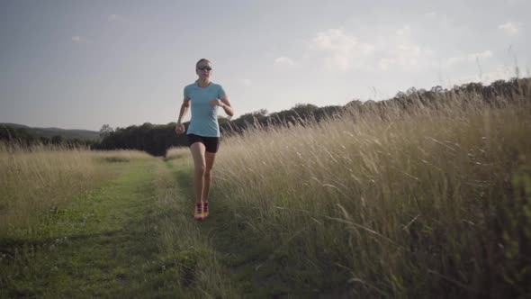 Slow Motion Woman Running on Path Through High Dry Grass