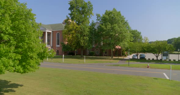 POV Flying Past Tree and Towards a Colonial Revival Architecture Style Building alt