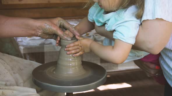 Kid Girl Learn How To Create Cup on Pottery Workshop