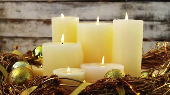 Burning candles with christmas decoration on wooden plank alt