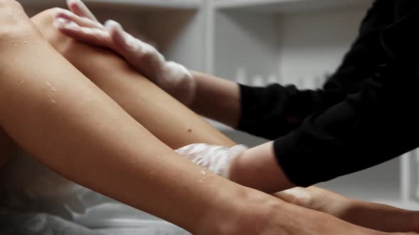 Waxing Procedure  Depilation Master Applying Oils on the Smooth Legs of Her Client alt
