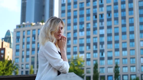 portrait of a charming blonde woman against the backdrop of skyscrapers