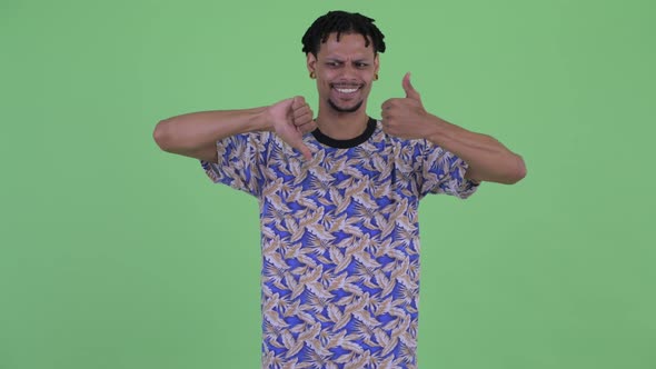 Confused Young African Man Choosing Between Thumbs Up and Thumbs Down alt