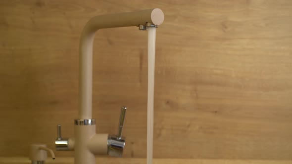 Woman Opens Water Tap in Kitchen