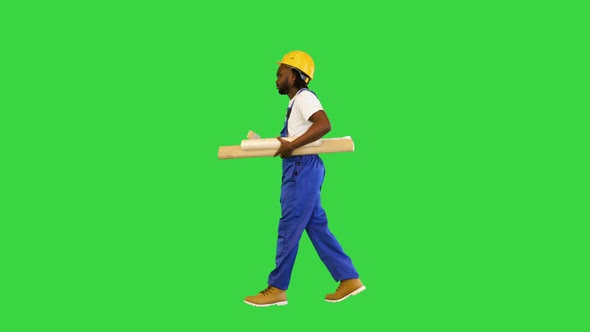 Handyman Man in Protective Helmet Hold Wallpaper Rolls Walking and Pointing with a Brush to the alt