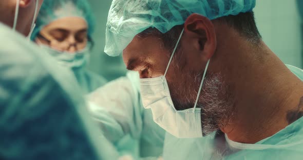 Surgeon Performs the Surgical Operation Together with a Team of Doctors