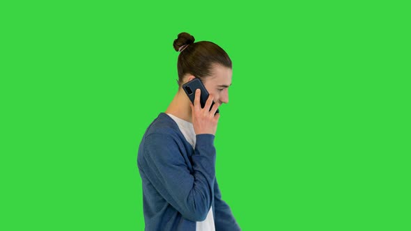 Young White Man Walks Talking on His Smartphone and Smiling on a Green Screen Chroma Key