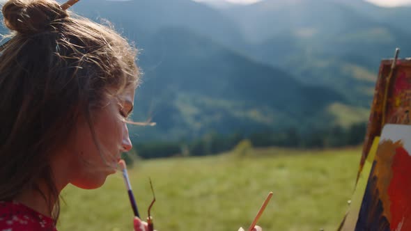Young Woman Painting Scenery Mountains Close Up alt