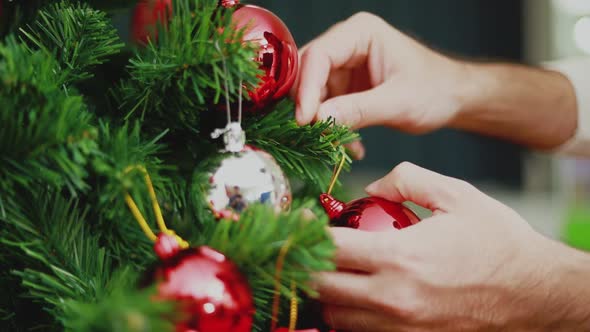 Close up hands Asian man holding red ball Christmas decorate Christmas tree.