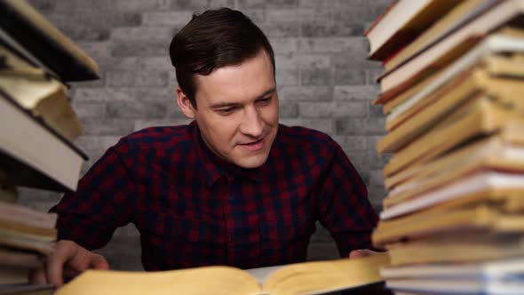 Man Student Boring Reading Book at Library with a Lot of Books in University. Student Disheartened alt
