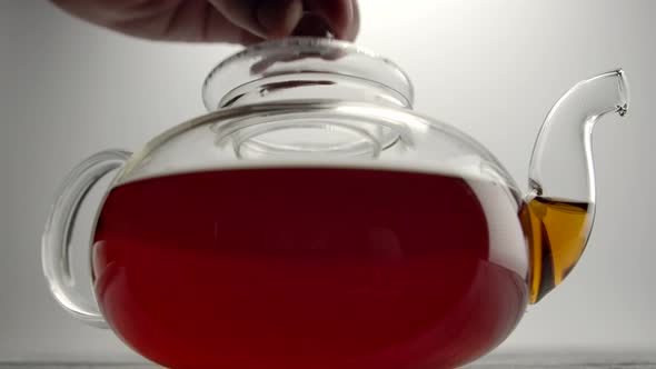 Transparent Teapot with Classic Brown British Tea on Wooden Table alt