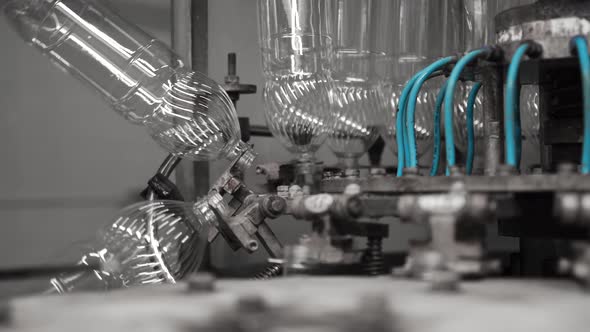 Plastic Bottles Travel Through an Automated Bottling Line for Drinking Water