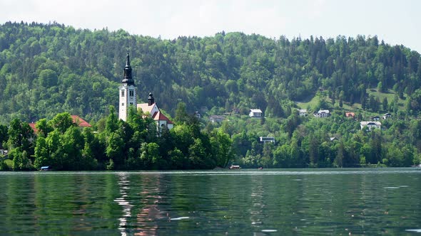 Nice hot summer day at calm Lake Bled in Slovenia with church in the middle alt
