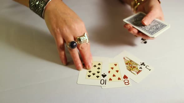 Female Hands With Gold Jewelery Lays Out Playing Cards