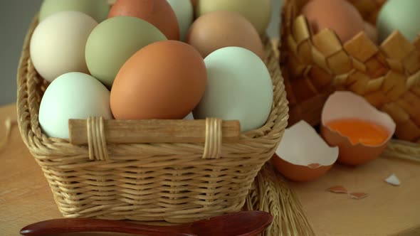 Wicker Basket with Fresh Raw Eggs Rotate in Wooden Cutting Board