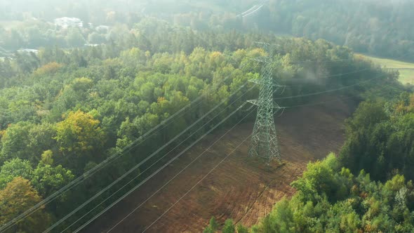 Turn Around High Voltage Electric Transmission Tower or Pylon on the Terrain Through the Clouds alt