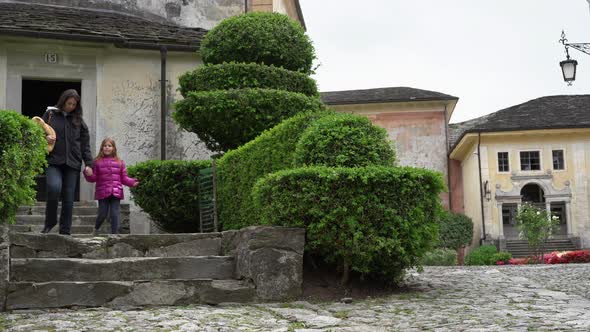 A mother and her little daughter carrying a teddy bear visiting the sacred mountain of Varallo chris alt