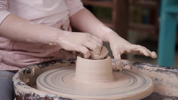 Small Child Girl Molding Wet Clay in Craft and Cozy Studio Room