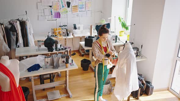 Top View of Young Happy Woman Designer Creating New Clothes Collection Working at Tailor Studio Slow alt