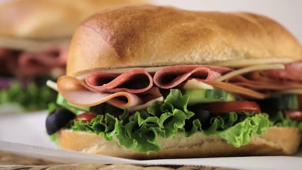 Sub sandwich with fresh vegetables, lunch meat and cheese on hoagie roll. alt