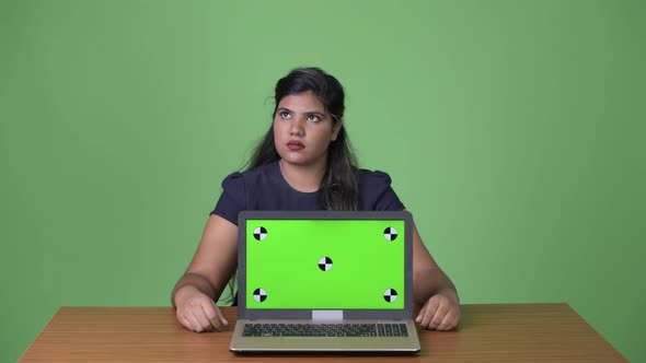Young Overweight Beautiful Indian Businesswoman Against Green Background alt