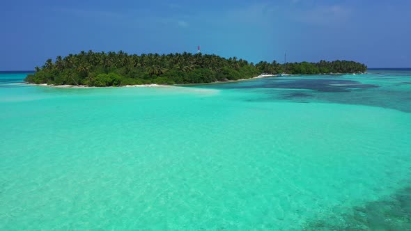 Calm crystal water of turquoise lagoon surrounding tropical island with lush vegetation and palm tre alt