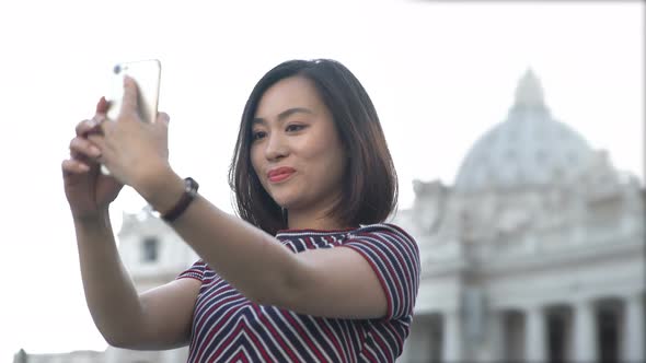 chinese young woman shooting selfies with background San Peter, Rome alt
