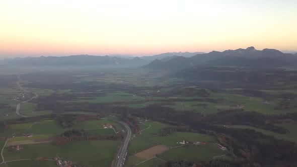 Aerial View of Green Meadows with Villages and Forest in Austrian Alps Mountains alt
