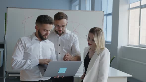 Partners Look on the Laptop's Screen and Discuss It alt