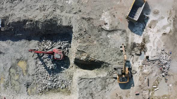 Crawl excavator at the construction site is handing ground to the loader. alt