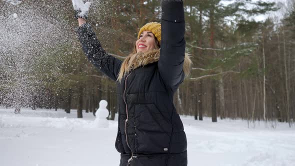 Woman Is Throwing Some Snow in the Air Enjoying the Cold Season alt