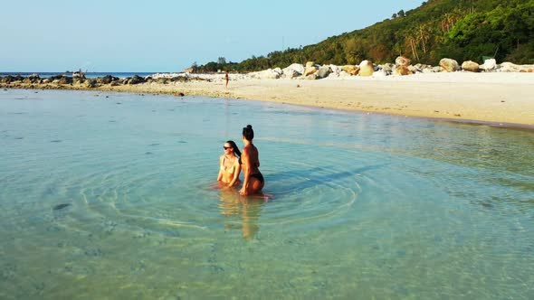 Girls look beautiful on idyllic shore beach break by shallow water with bright sand background of Th alt