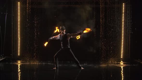 An Exciting Night Fire Show Performed By a Stylish Man Performing in the Rain. Silhouette of Fakir alt