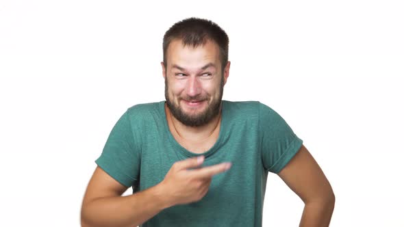 Headshot Portrait of Bearded Cheerful Man 30s Wearing Shirt Laughing at Someone Pointing Finger alt