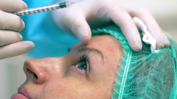 Closeup Picture of Adult Woman Getting Botox Injection in Forehead Lying in Medical Hat in Clinic By alt