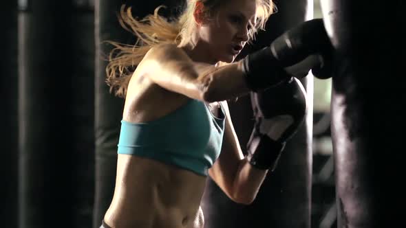 Woman does Muay Thai kickboxing training at the gym. alt