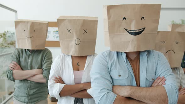 Portrait of Businesspeople Wearing Paper Bags with Emoji on Heads Standing with Arms Crossed in alt
