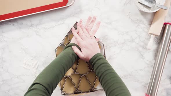 Flat lay. Step by step. Cutting out shapes with Christmas cookies cutter from sugar cookie dough. alt