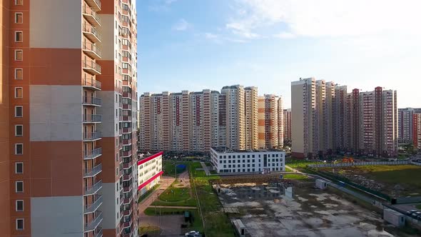 A drone flies over a road in the courtyard of a residential area. City infrastructure.