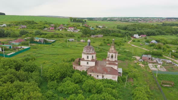 Old Christian Church in the Middle of the Green Field with Some Residential Areas alt