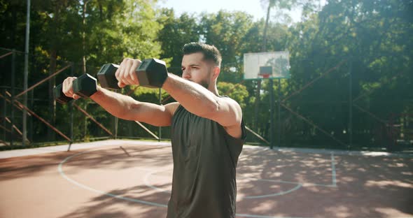 Sporty Man Lifting Weights with Both Hands in a Public Park Biceps Training alt