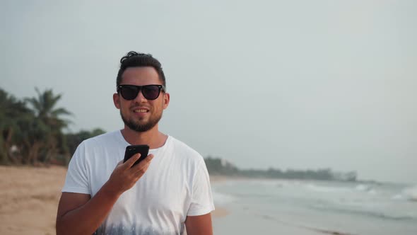 Handsome Young Tourist Man Use Phone Smartphone Audio Message Voice Recognition Application Ai alt