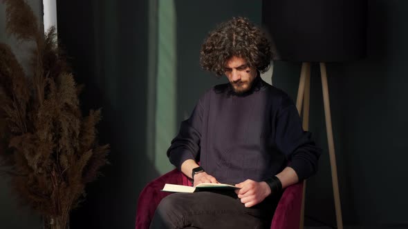 Man Sitting Near Window and Reading a Book at the Sunset Admiring the View alt