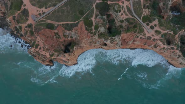 Aerial Birds Eye Overhead Top Down of Lagos Cliff Coast on Windy Day Portugal Rising Up View alt