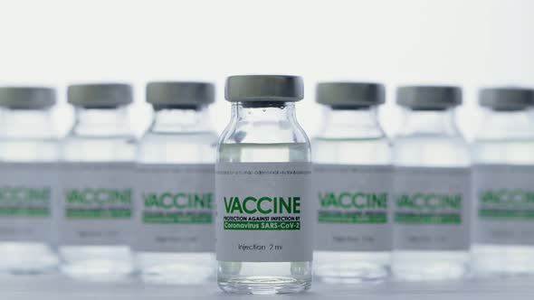 Doctor with Glove Takes Flask of Vaccine for Injection for Coronavirus COVID19 Cure in Research alt