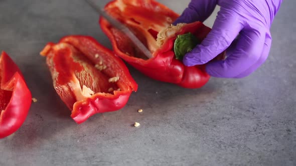 The chef removes seeds from red peppers and cuts them