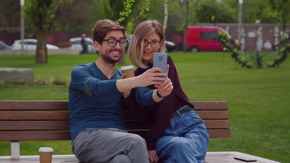 Two friends with glasses take selfie with phone alt