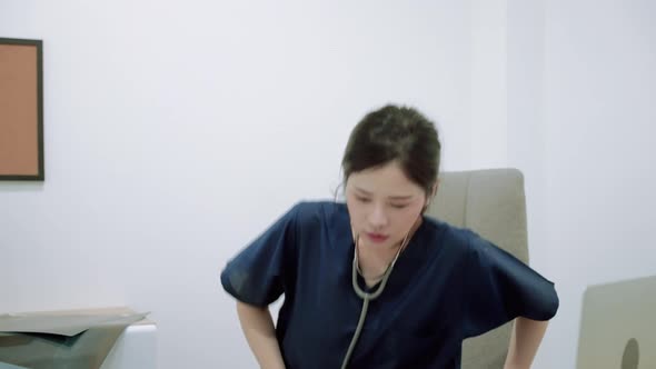 young Asian doctor walks into a office where she is stressed out of being a surgeon