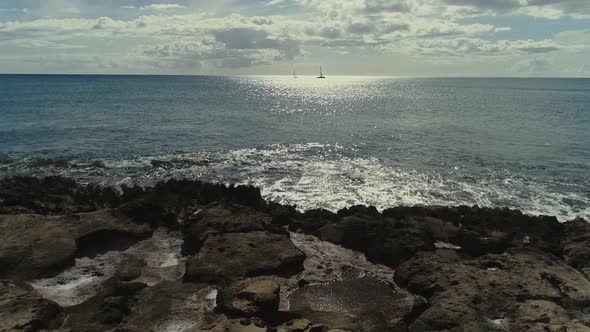 Ascending view rocky pacific ocean shore, Sailing boats silhouette horizon, Hawaii alt