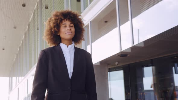 Smiling Businesswoman Walking Outside Office alt